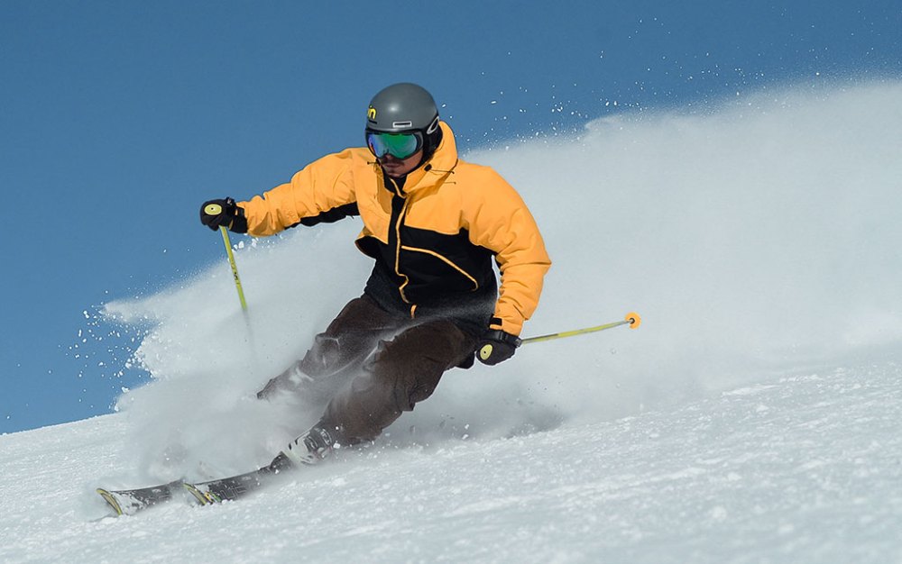 a man riding skis down a snow covered slope