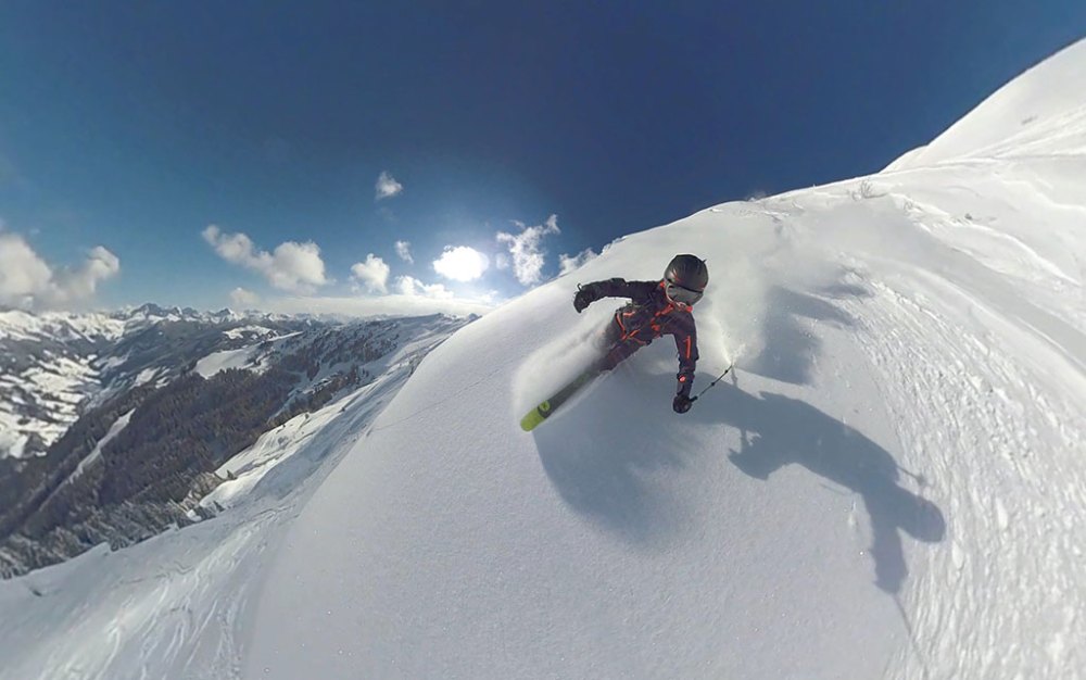 a man riding a snowboard down a snow covered slope