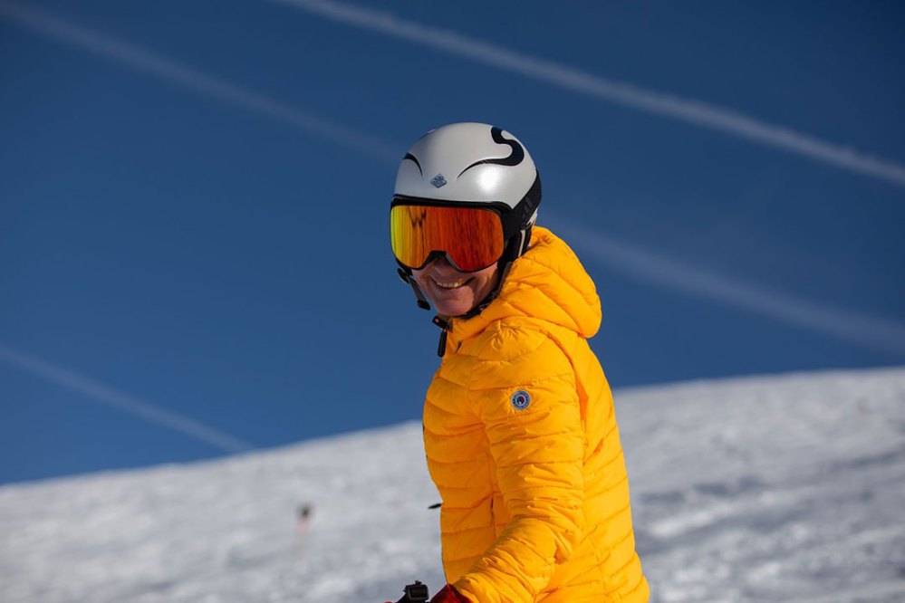 a man riding a snowboard down a snow covered slope