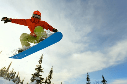 a man flying through the air while riding a snow board